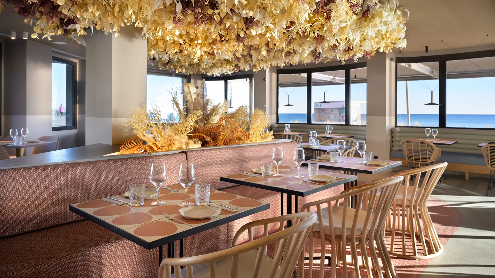 Sala del Restaurant Akquaaa a Calafell, amb la instal·lació de flors seques al sostre i els finestrals al mar