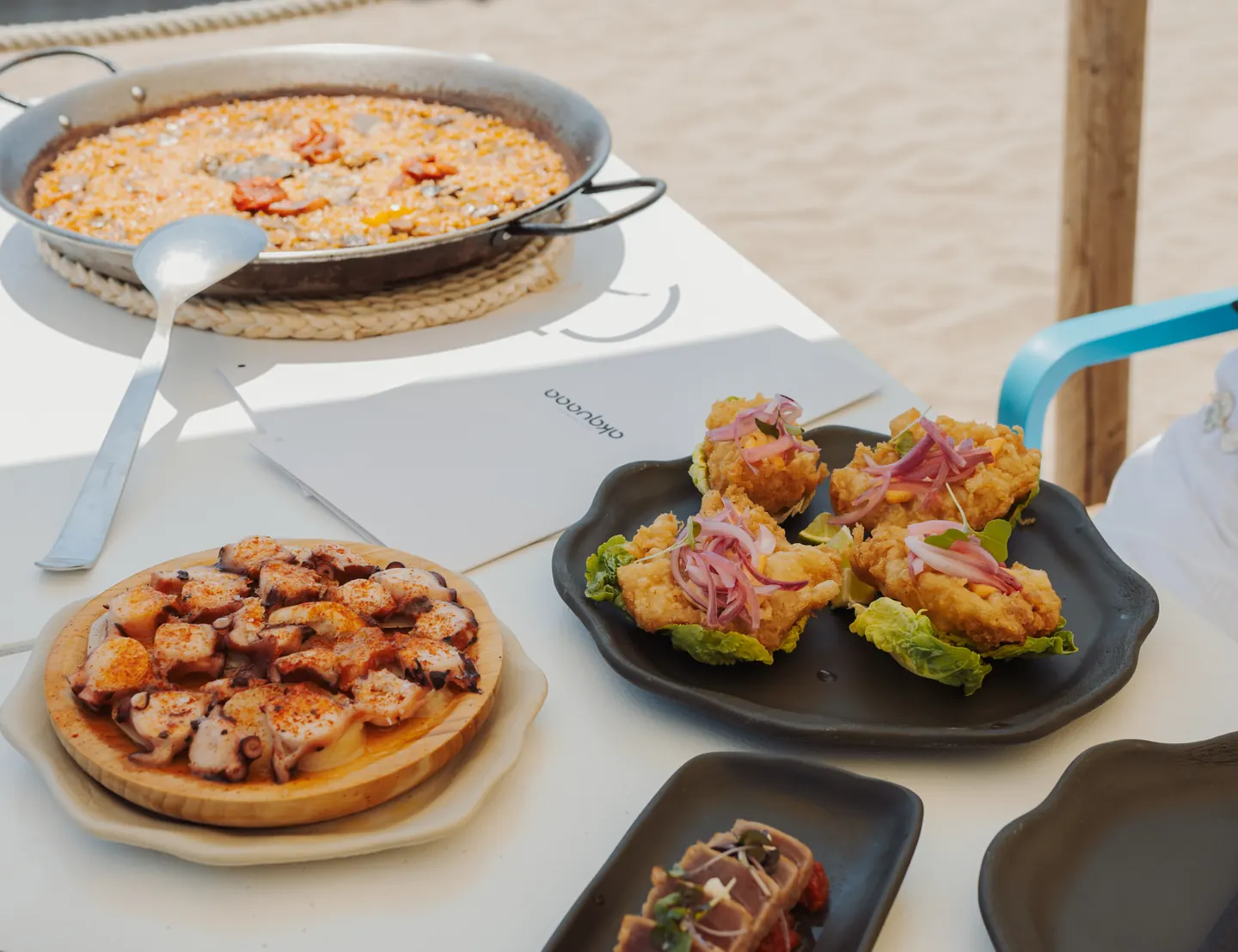 Mesa del chiringuito Akquaaa con arroz y picoteo frente al mar